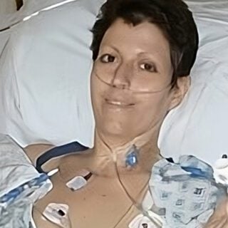 Heather Von St. James lies in a hospital bed, post-surgery.