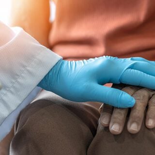 Doctor holding hands with an end-stage mesothelioma patient